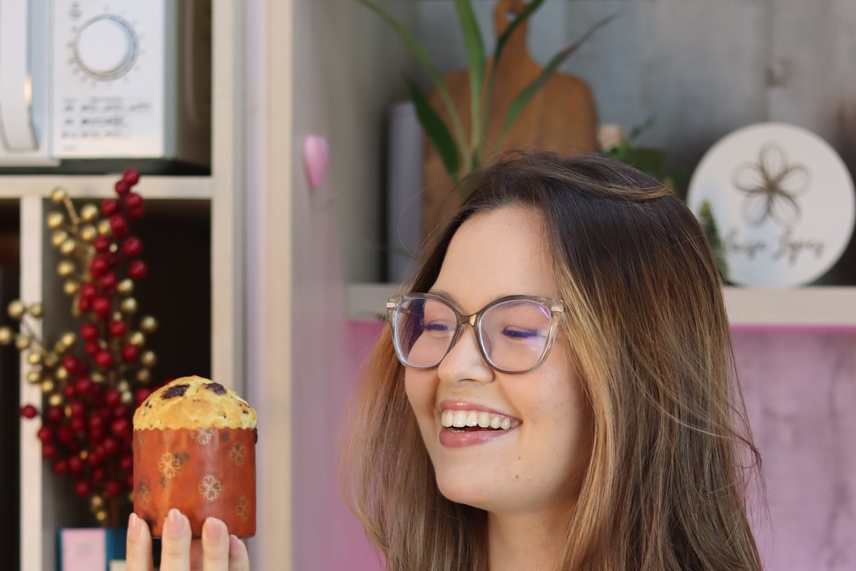 Chef Laíse Lopes atrás da mesa com a produção inteira de panetones